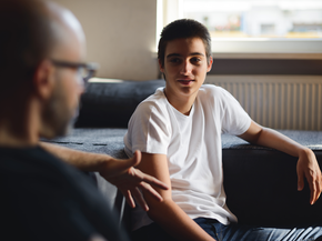 Teenage boy smiles while talking to psychiatrist