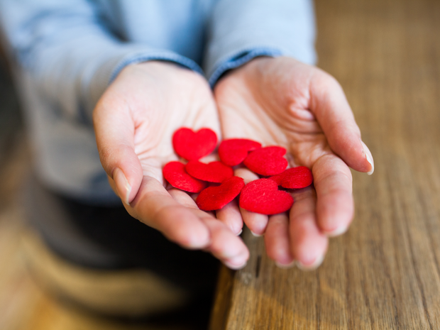 A hand holds cutout felt hea