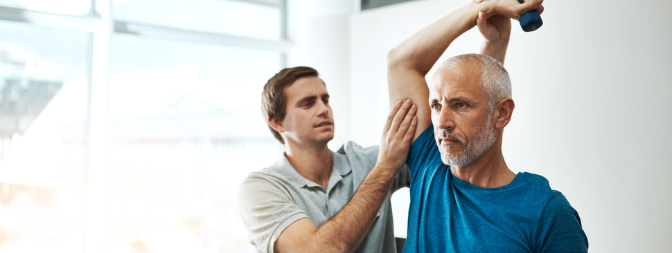 A man stretching being helped by a physical therapist
