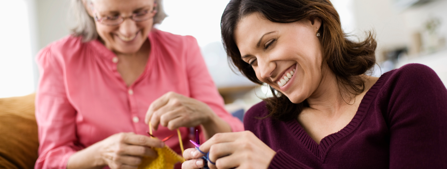 Older mother and daughter knitting