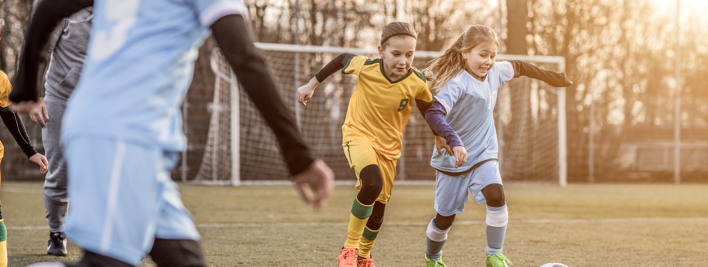 Two youth soccer players battling for the ball