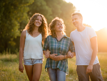 Woman walks with children in the sunset