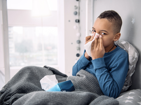 Young boy blowing his nose