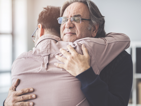 dad hugging son with quiet emotion