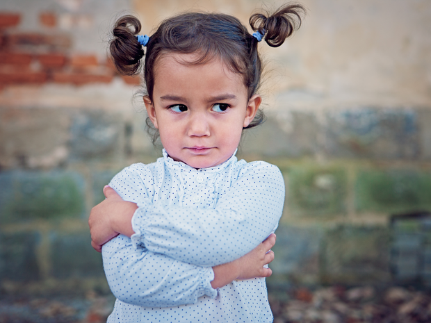 Toddler with her arms folded.