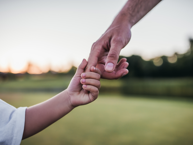 adult holding a child's hand