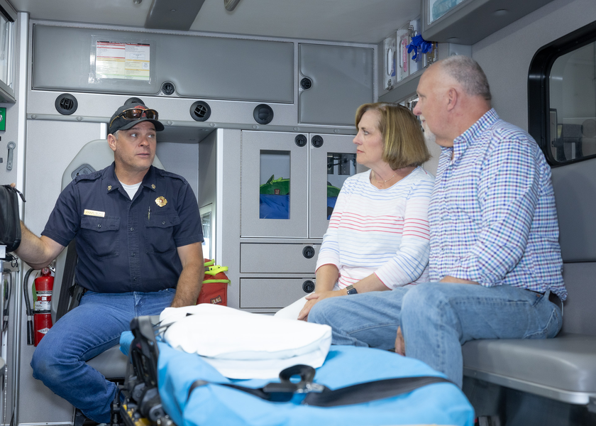 Couple getting a tour of the interior of an ambulance.
