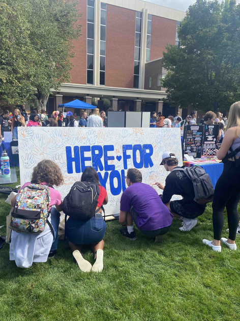  Students sign a poster.