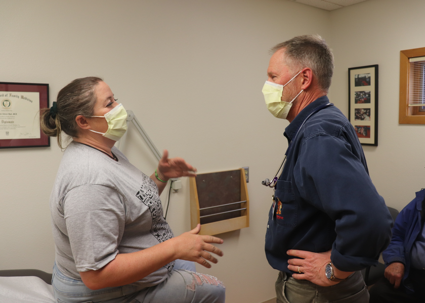 Man and woman in masks carry conversation
