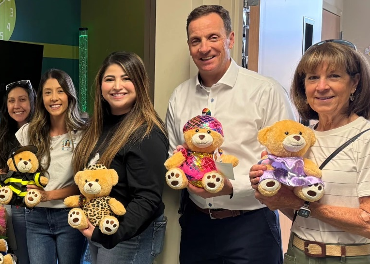 Dr. Henry Thompson, second from right, helping deliver Miracle Bears at St. Luke's Children's Hospital following the annual Kid For A Night fundraising event.