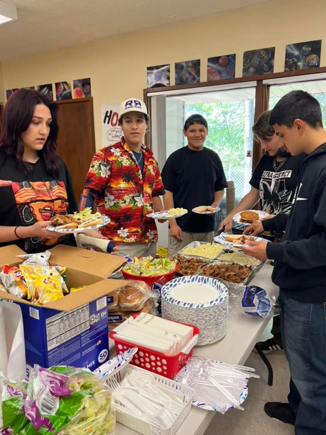  Young adults standing around a table of food