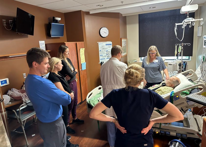  Medical personnel surround patient in hospital bed