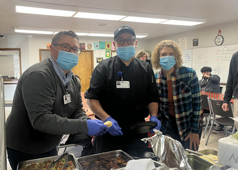 St. Luke's staff serving food to students.