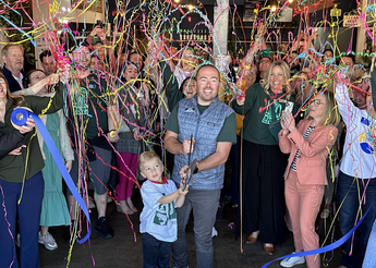 Celebration event with supporters, streamers and ribbon cutting.