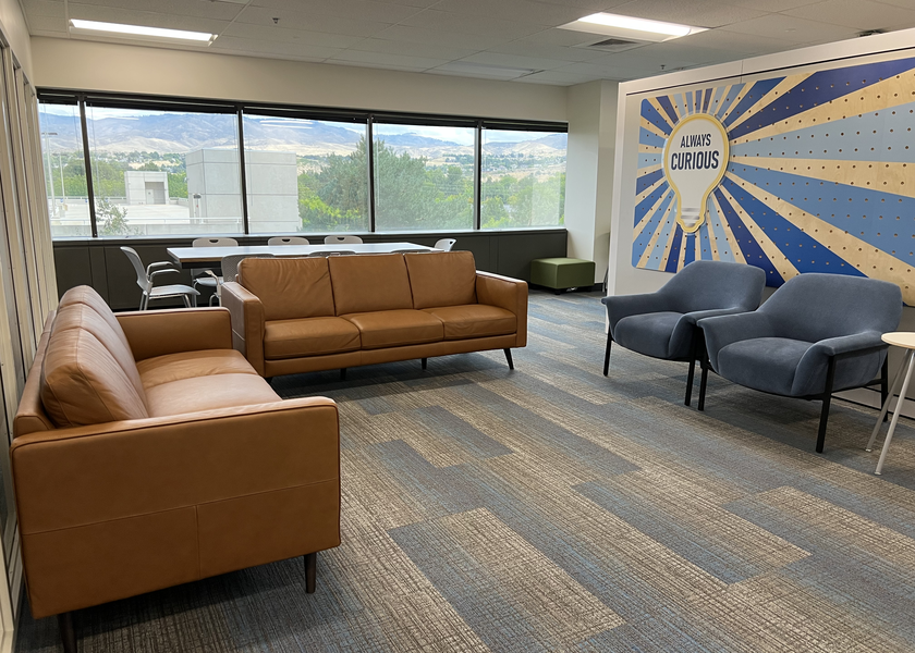 Sitting area looking out to hills with painted mural on one wall. 