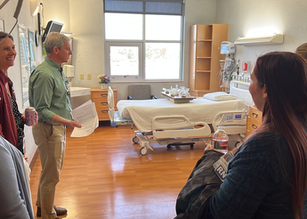 Five people examine a hospital room