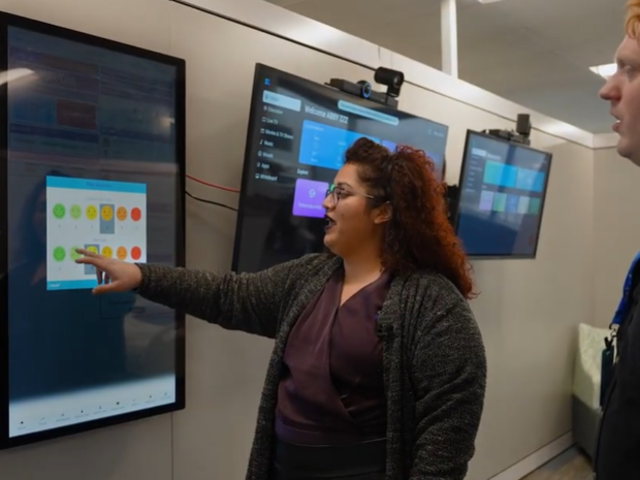 Two people look at a screen displaying training medical analytics