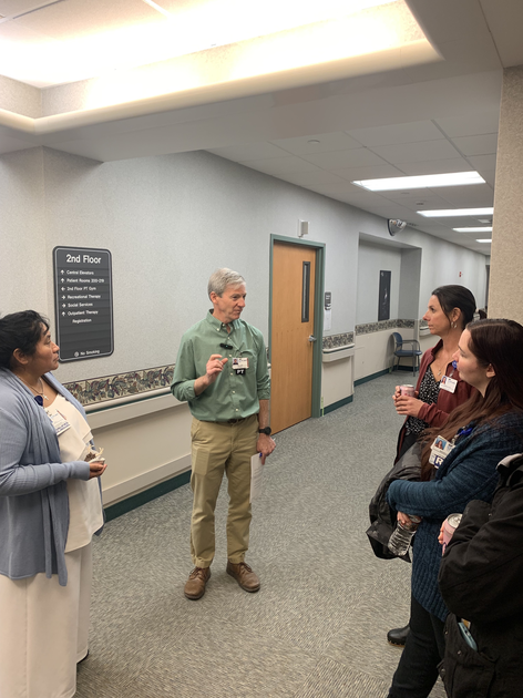Man speaking to group in hallway