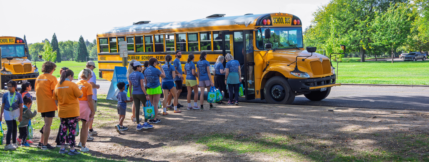 FItOne participants boarding a school bus shuttle at Ann Morrison Park