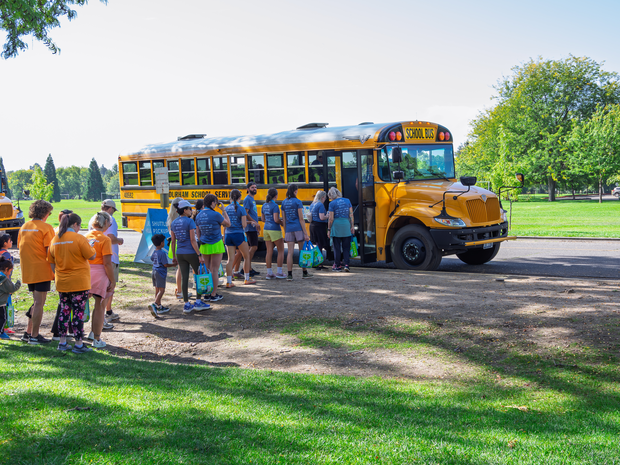 Racers loading onto a school bus shuttle