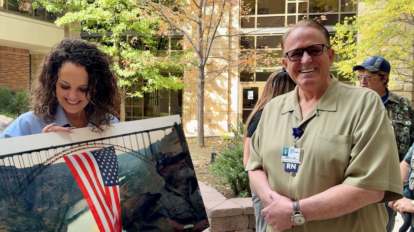  Joni Huff and Fred Cunha pose with a photograph of Cunha's.
