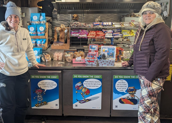 Injury prevention team members standing next to safety signs.