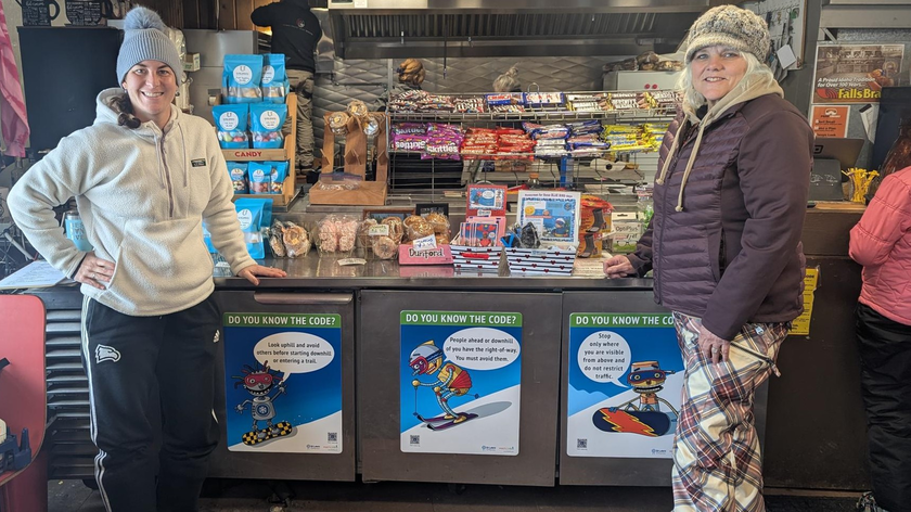 Injury prevention team members standing next to safety signs.