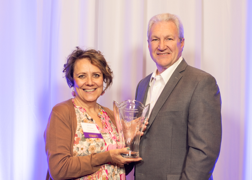  Two people standing with woman holding award