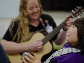 Music therapist plays guitar for a patient