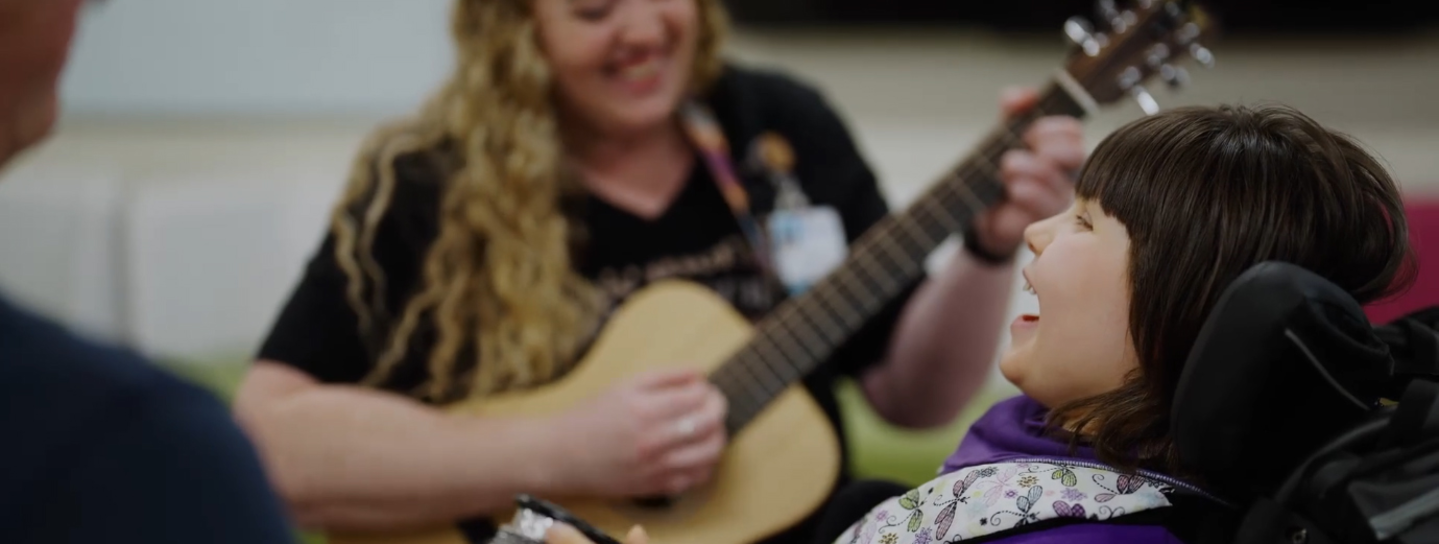 Music therapist play guitar for a patient