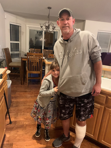  Man in cast stands with young girl next to him