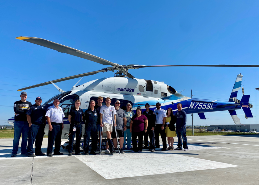  Large group standing outside of helicopter