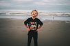 Young boy stands proudly on the beach