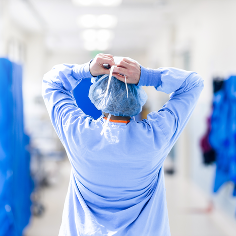 A nurse adjusting their scrub cap