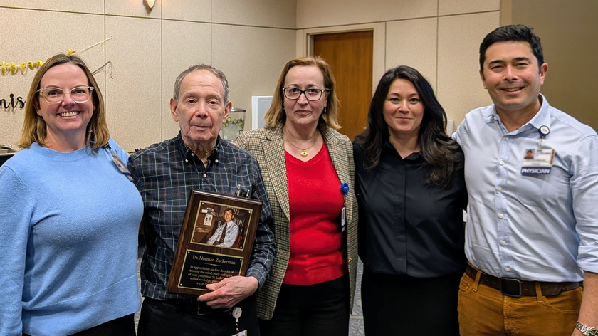 St. Luke’s doctor holding commemorative plaque with fellow team members standing with them.