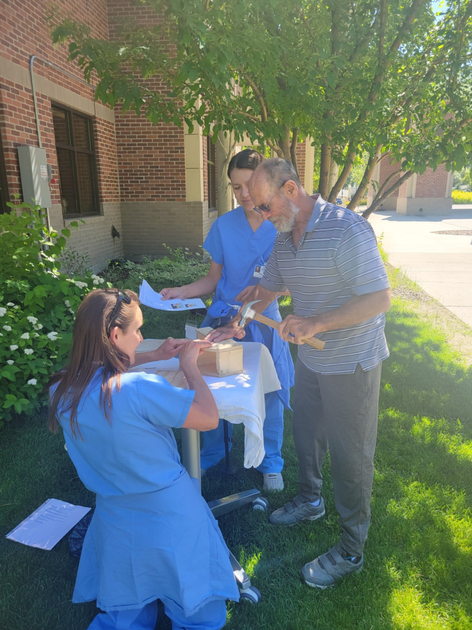  Two women and man build birdhouse