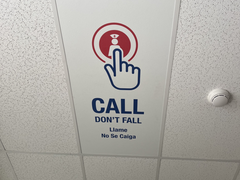  Sign on ceiling that encourages patients to call for help rather than risk a fall.