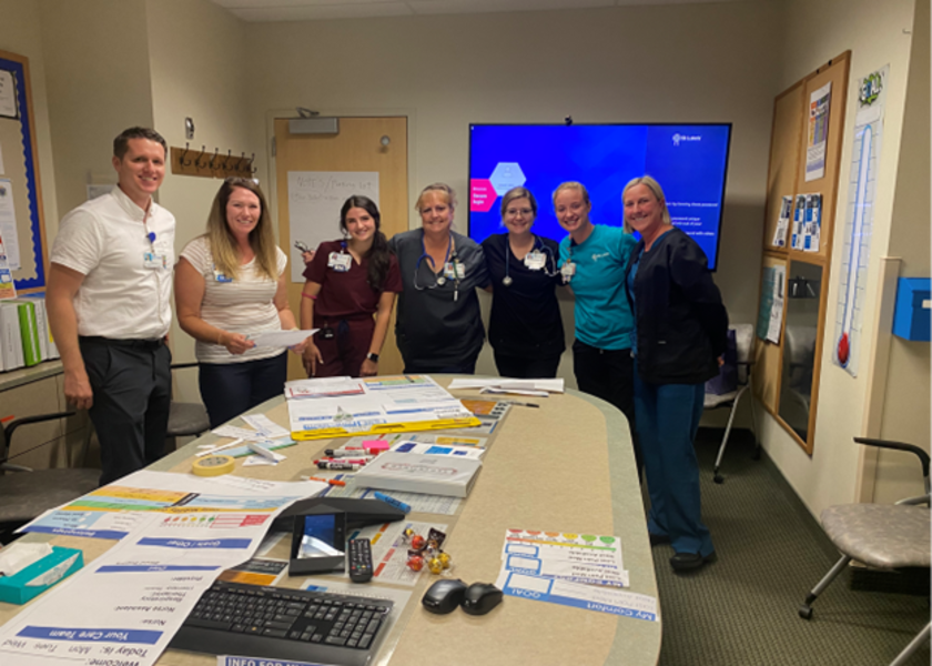 St. Luke's staff posing together in conference room after assembling education materials.