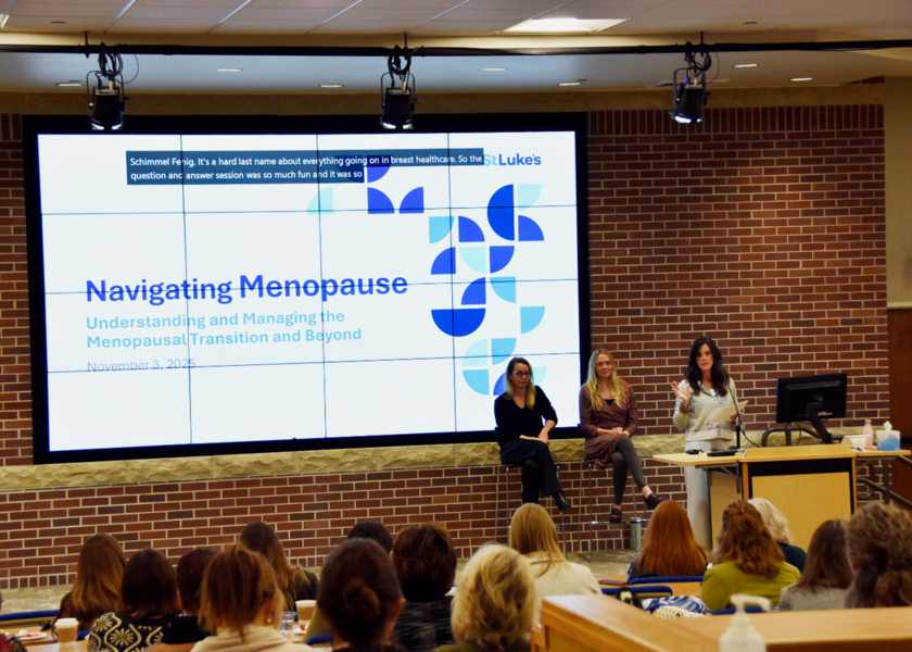 Three women standing in front of an audience.