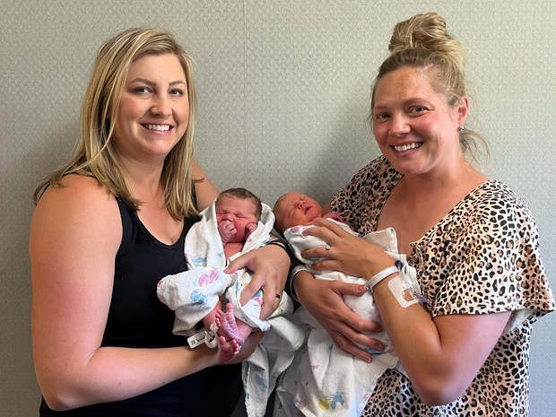 Two women holding newborn babies