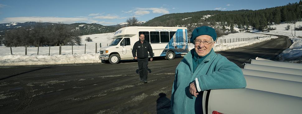 Senior woman standing near a bus.