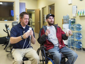 Patient and Provider practice hand eye coordination in hospital room.