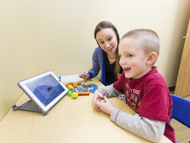 Smiling works with Provider holding tablet.