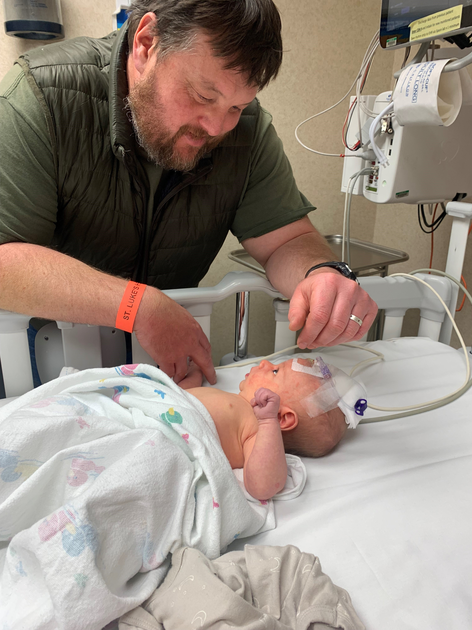  Steve looks down at his newborn.