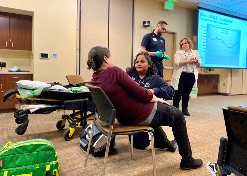 Medical personnel caring for woman in a chair