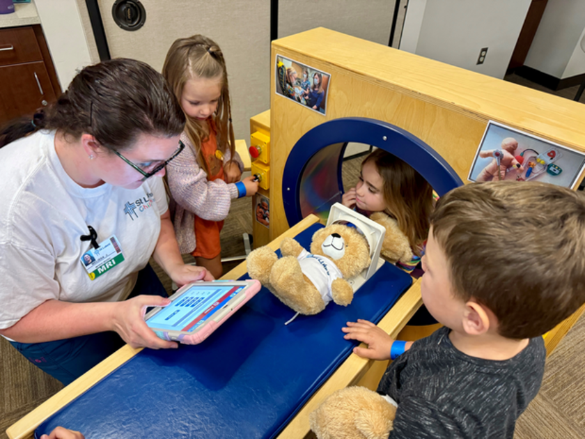 Children help give a bear a play MRI