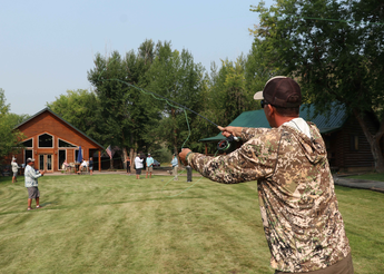People affected by cancer practicing their fly fishing casts on the lawn.