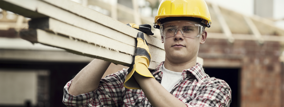 Construction worker carrying boards