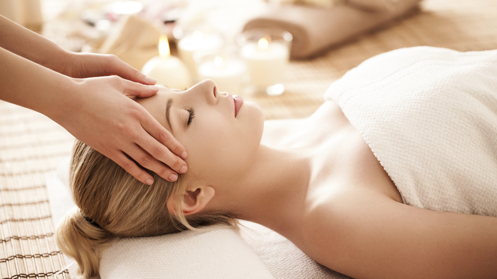 Hands hovering over a woman lying on a table.