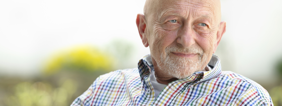 An older man looks off in the distance happily